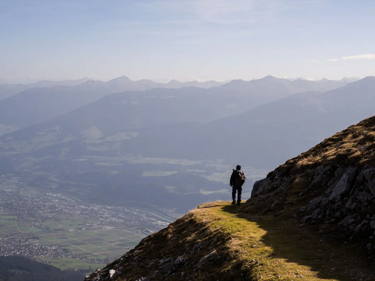Eine Person blickt von einem Aussichtspunkt in die Weite