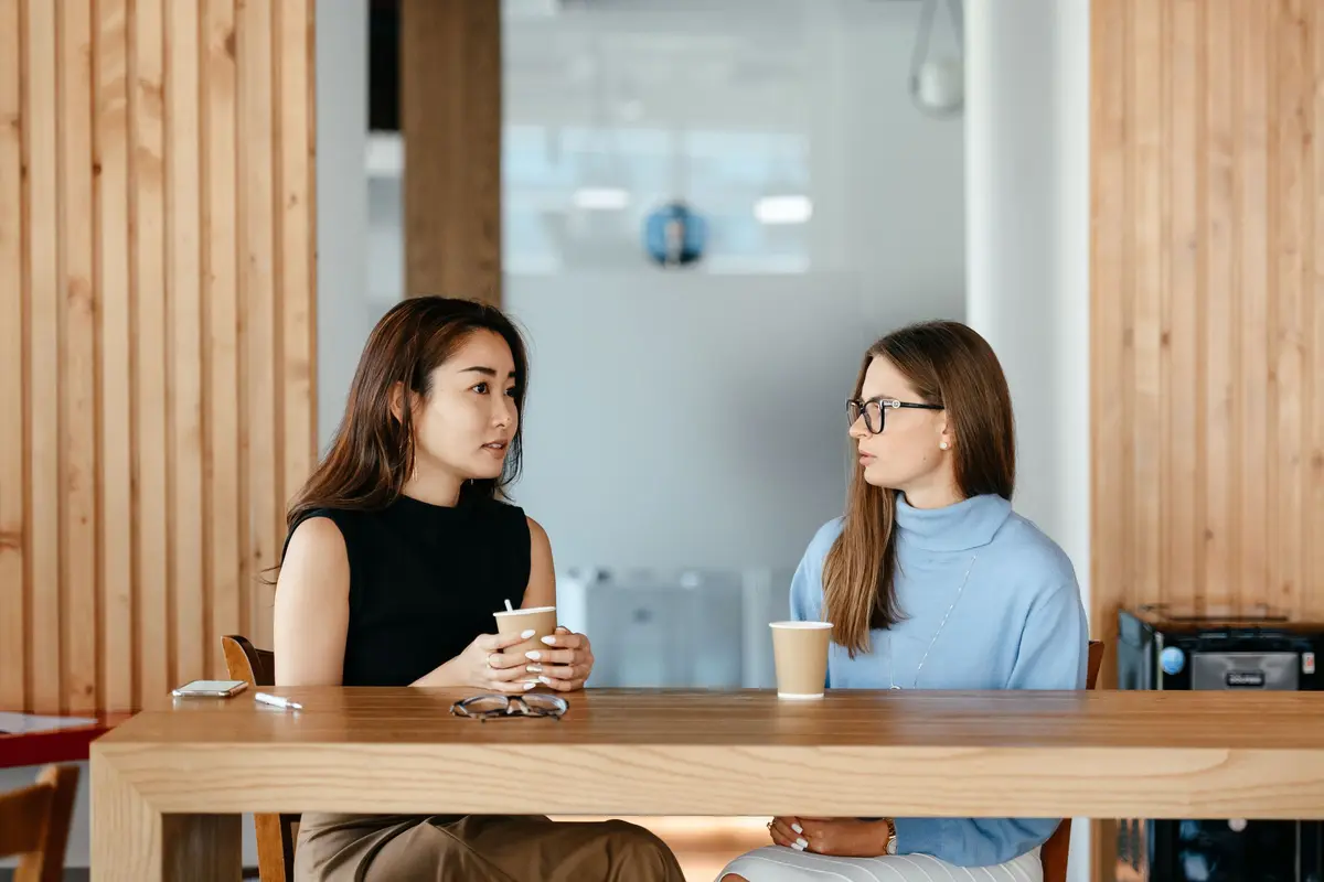 Zwei Frauen unterhalten sich warm und offen bei einem Kaffee